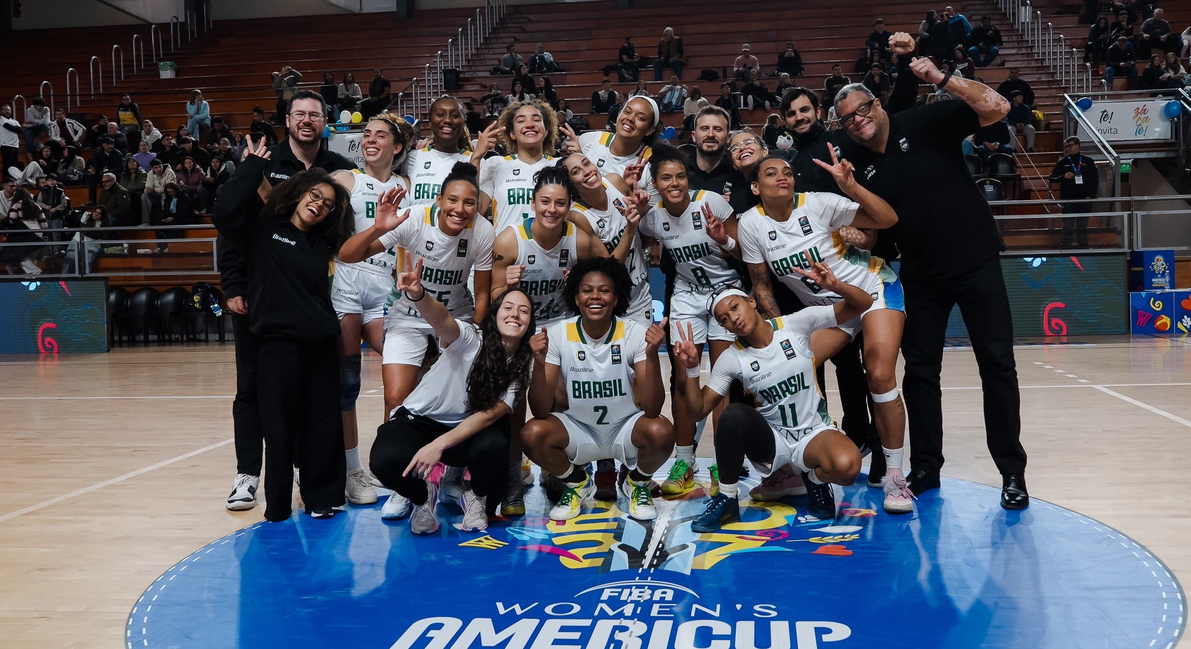 La Selección Brasileña de Baloncesto Femenino celebra en cancha, con Joana Paiva junto al cuerpo técnico.